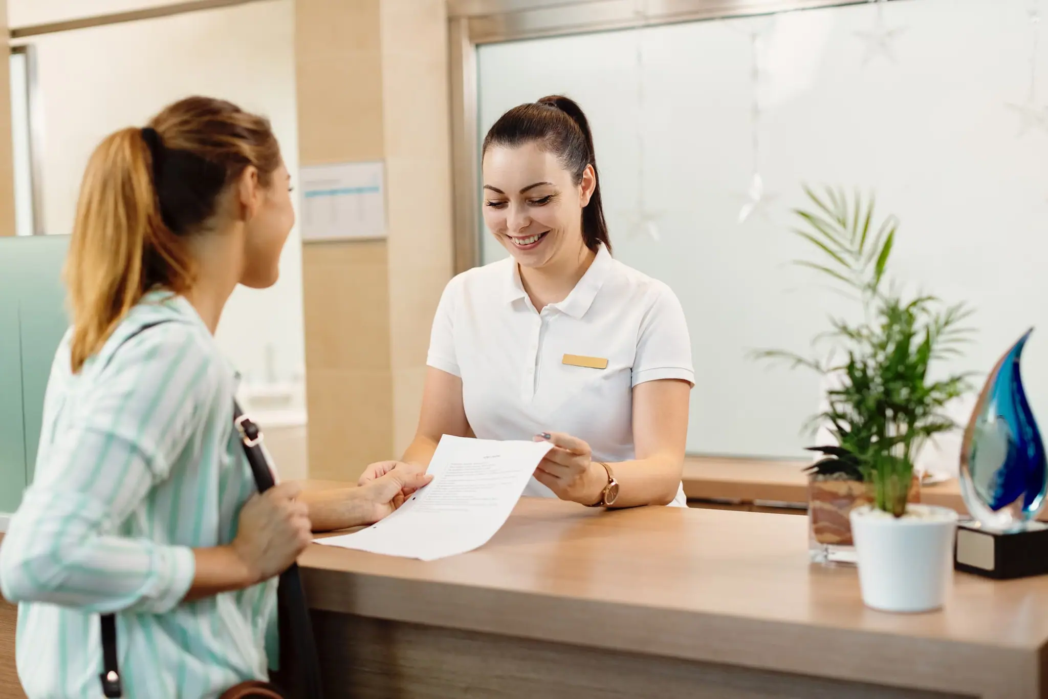 Receptionist welcoming a patient at a healthcare practice front desk