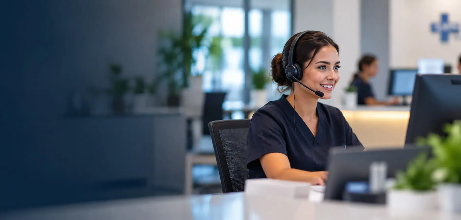 Medical receptionist wearing a headset handling patient calls at a clinic desk
